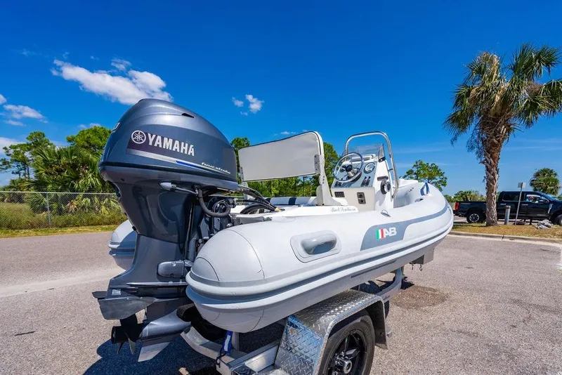 Slide: The Image of A Yamaha-powered AB inflatable boat on a trailer under a clear blue sky. - 59