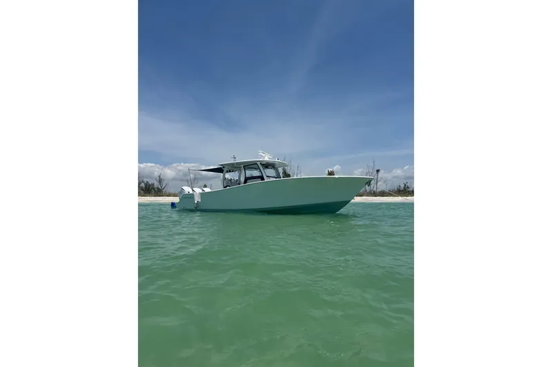 The Image of 2021 Sportsman Open 352 Center Console boat on calm water under clear blue sky. - 0