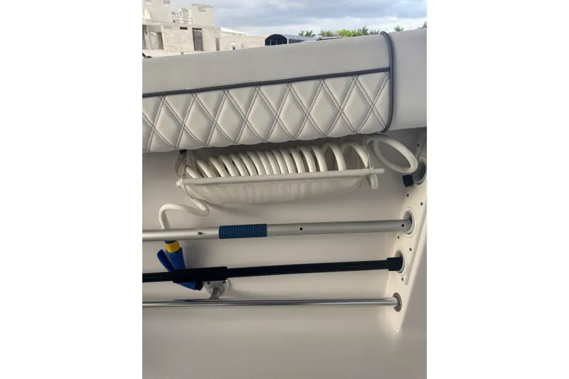 Slide: The Image of 2021 Sportsman Open 352 Center Console interior with coiled hose and rod holders. - 49