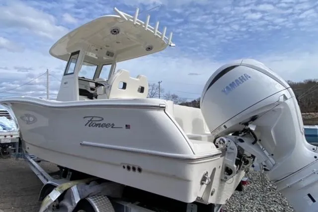 Slide: The Image of 2026 Pioneer 250 Pelagic boat on trailer, parked outdoors under cloudy sky. - 22