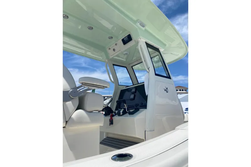 Slide: The Image of Interior view of 2026 Pioneer 250 Pelagic boat, featuring helm and seating under a clear sky. - 3