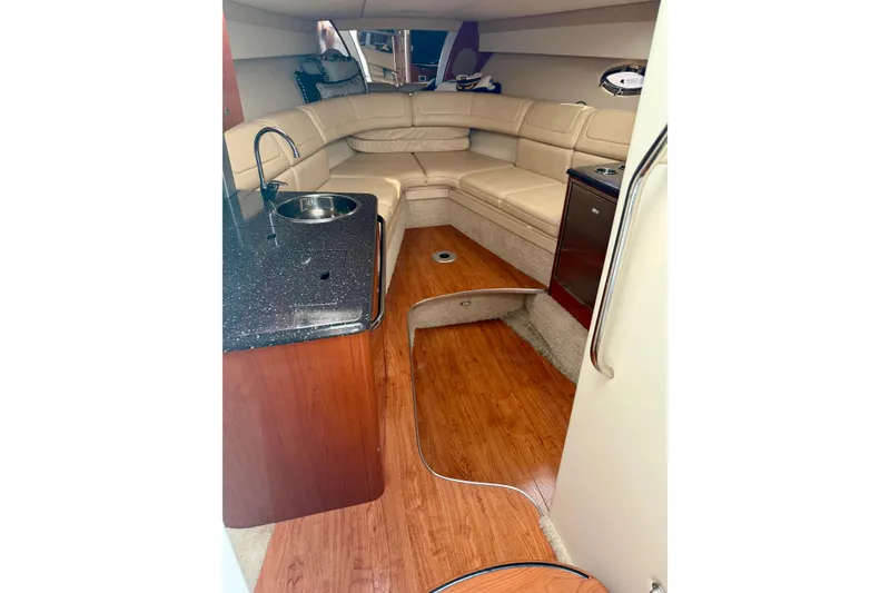 Slide: The Image of 2008 Formula 350 Sun Sport interior with beige seating, kitchenette, and wood flooring. - 14