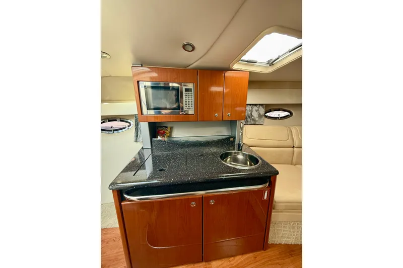 Slide: The Image of 2008 Formula 350 Sun Sport cabin kitchen with microwave, sink, and wooden cabinetry. - 16