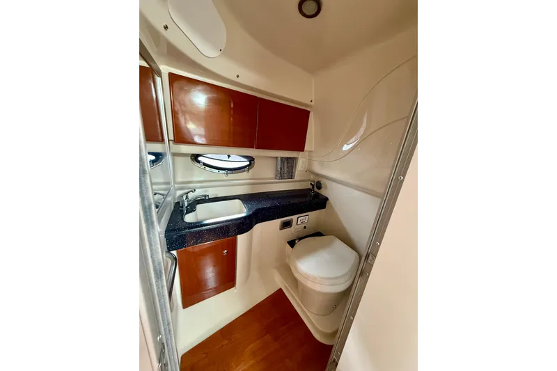 Slide: The Image of 2008 Formula 350 Sun Sport boat bathroom with sink, toilet, and wooden cabinets. - 18