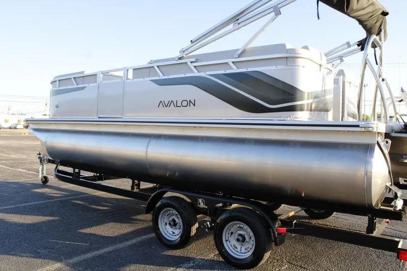 Slide: The Image of 2026 Avalon VLS QUAD LOUNGER 21 pontoon boat on trailer in parking lot. - 7