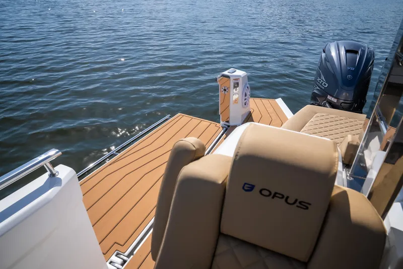 Slide: The Image of 2024 Opus OPUS 12 boat with luxurious seating and powerful engine on calm water. - 14