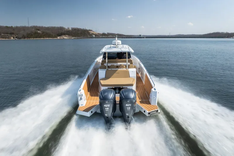 Slide: The Image of 2024 Opus OPUS 12 boat cruising on a lake with dual outboard engines. - 8