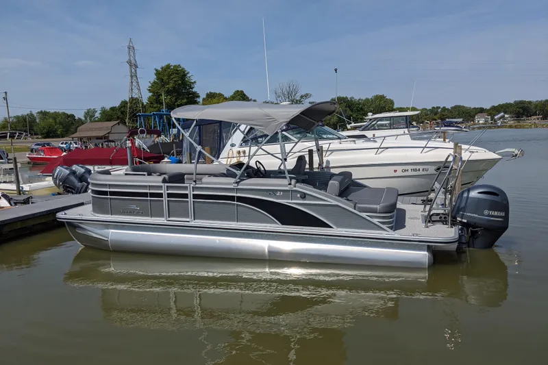 The Image of 2020 Bennington SXP 23 SSBXP pontoon boat docked on a calm lake. - 0