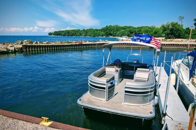 Slide: The Image of 2020 Bennington SXP 23 SSBXP pontoon boat docked by scenic lake. - 11