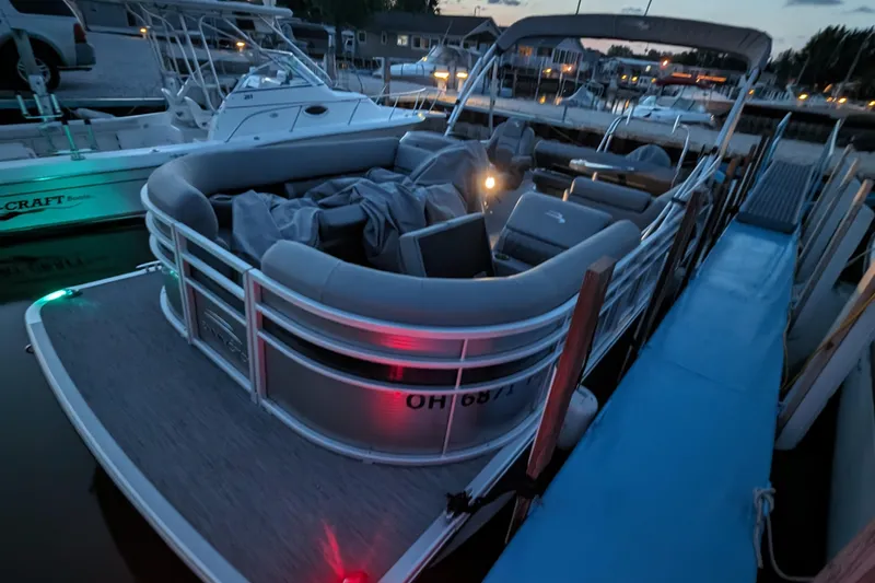 Slide: The Image of 2020 Bennington SXP 23 SSBXP pontoon boat docked at sunset with ambient lighting. - 12