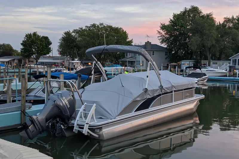 Slide: The Image of 2020 Bennington SXP 23 SSBXP pontoon boat docked at a marina during sunset. - 13