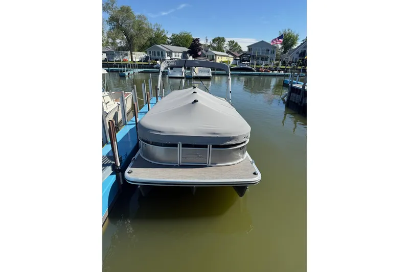 Slide: The Image of 2020 Bennington SXP 23 SSBXP pontoon boat docked with cover on calm water. - 18
