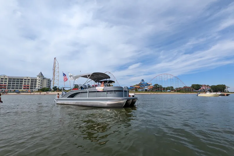 Slide: The Image of 2020 Bennington SXP 23 SSBXP pontoon boat on a lake near amusement park. - 3