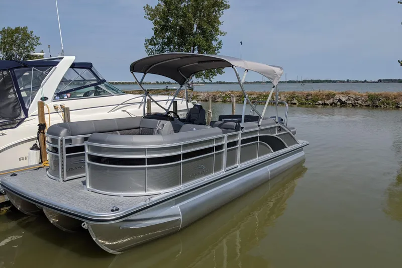 Slide: The Image of 2020 Bennington SXP 23 SSBXP pontoon boat docked on calm water. - 9