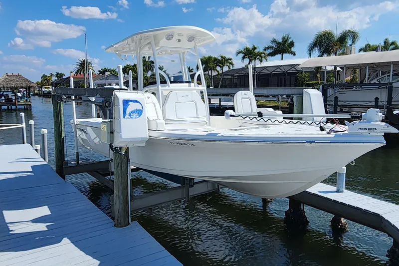 The Image of 2023 Sea Pro 248 Bay boat docked on a sunny waterfront with palm trees. - 0