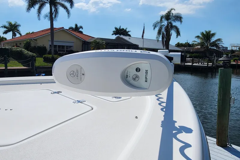 Slide: The Image of 2023 Sea Pro 248 Bay boat with Minn Kota Riptide trolling motor, docked by waterfront homes. - 12