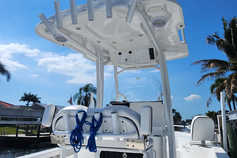 Slide: The Image of 2023 Sea Pro 248 Bay boat with T-top and blue ropes, docked under clear sky. - 13