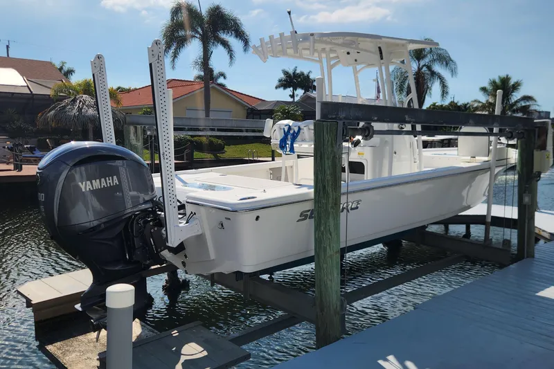 Slide: The Image of 2023 Sea Pro 248 Bay boat with Yamaha engine on a lift, dockside view. - 2