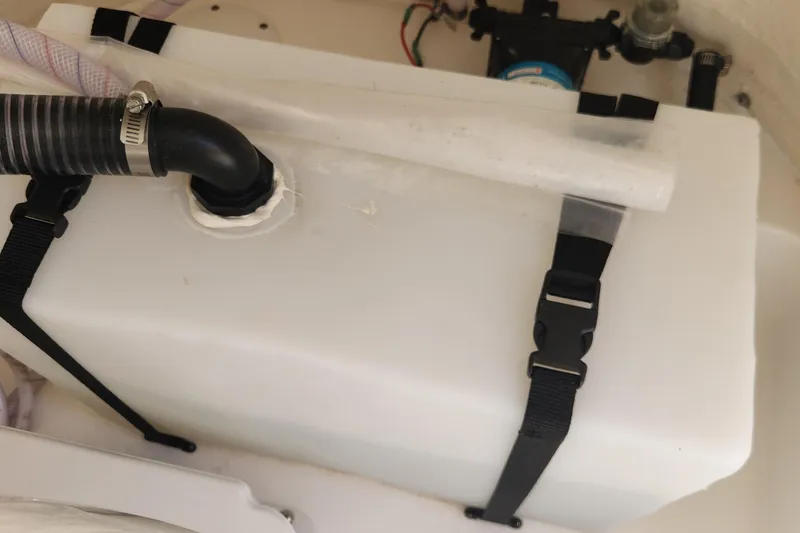 Slide: The Image of 2023 Sea Pro 248 Bay boat water tank with secure straps and hose connection. - 25