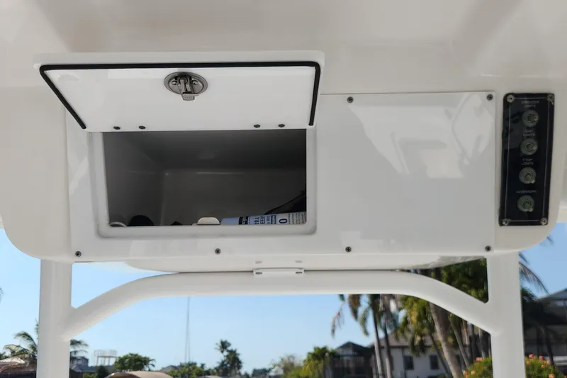 Slide: The Image of 2023 Sea Pro 248 Bay boat storage compartment and control panel under clear sky. - 29