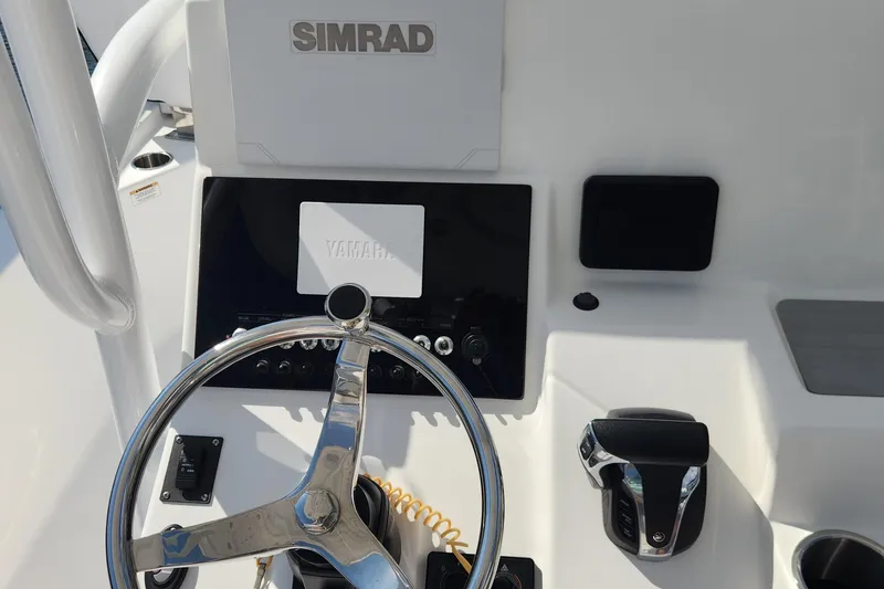 Slide: The Image of 2023 Sea Pro 248 Bay boat dashboard with steering wheel and Simrad display. - 30