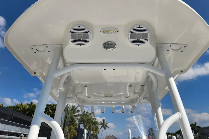 Slide: The Image of 2023 Sea Pro 248 Bay boat T-top with speakers and lights under a clear blue sky. - 35