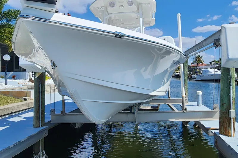 Slide: The Image of 2023 Sea Pro 248 Bay boat on lift, docked by waterfront homes. - 6