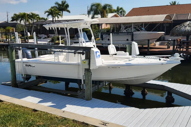 Slide: The Image of 2023 Sea Pro 248 Bay boat docked on a lift in a sunny marina. - 8