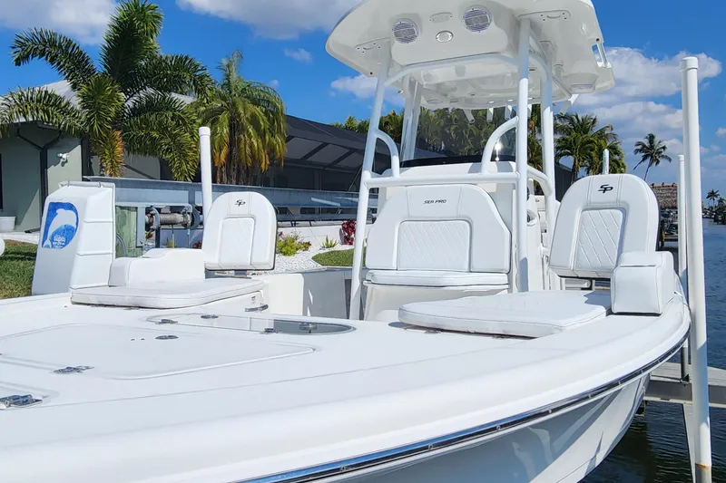 Slide: The Image of 2023 Sea Pro 248 Bay boat docked, featuring sleek white design and comfortable seating. - 9