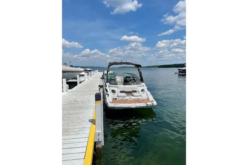 Slide: The Image of 2014 Crownline 255 SS boat docked on a sunny lake with blue skies. - 3