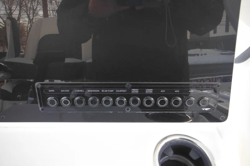 Slide: The Image of Control panel of a 2026 Tidewater 220 LXF boat with various switches. - 38