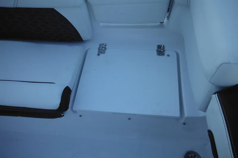 Slide: The Image of 2026 Tidewater 220 LXF boat interior with white seating and storage compartment. - 44