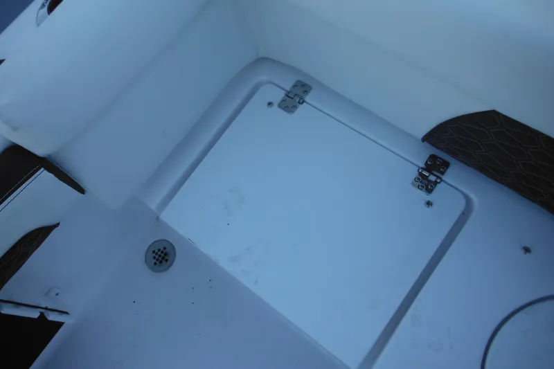 Slide: The Image of 2026 Tidewater 220 LXF boat interior with storage compartment and drain. - 49
