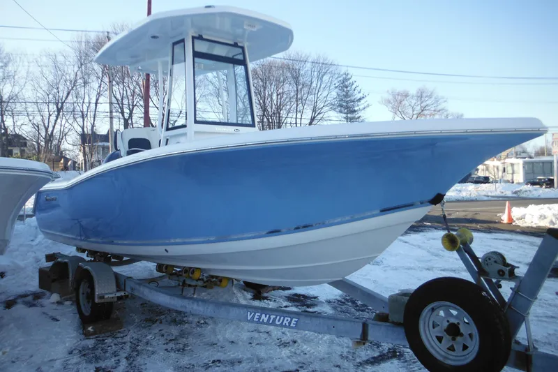 Slide: The Image of 2026 Tidewater 220 LXF boat on trailer, blue hull, snowy background. - 9