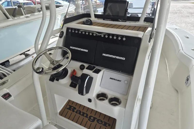 Slide: The Image of 2025 Ranger 2600 Bay boat dashboard with steering wheel, Humminbird electronics, and Mercury controls. - 10