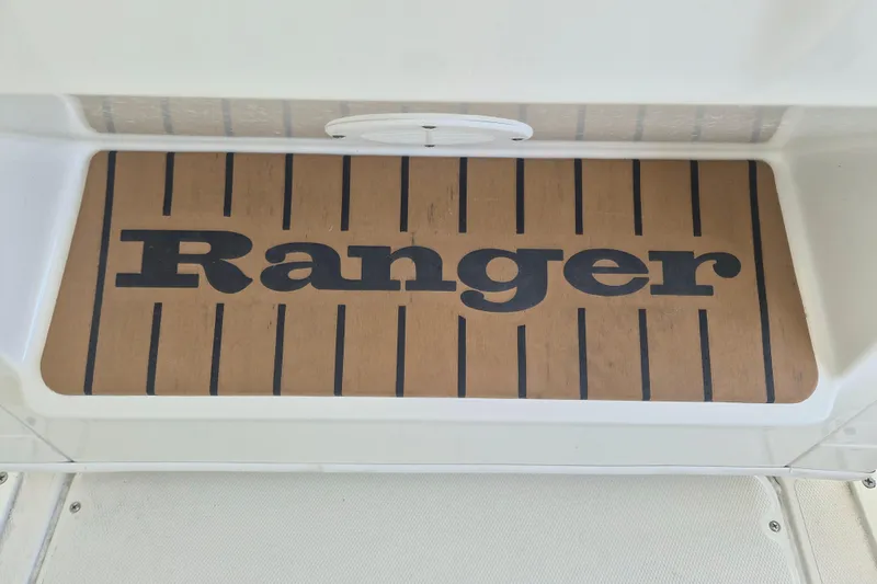Slide: The Image of Ranger 2600 Bay 2025 boat deck with logo, featuring wood-like finish. - 19