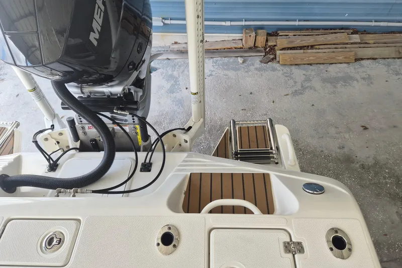Slide: The Image of 2025 Ranger 2600 Bay boat with Mercury engine and swim platform in a garage. - 21
