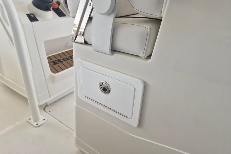Slide: The Image of 2025 Ranger 2600 Bay boat interior with white seating and storage compartment. - 23
