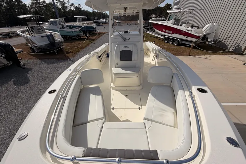 Slide: The Image of 2024 Cobia 262 Center Console boat with spacious seating, docked near other boats. - 10