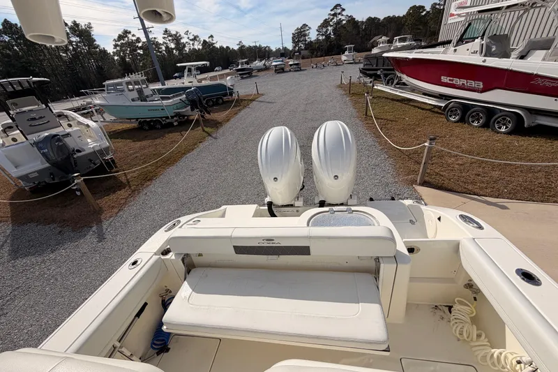 Slide: The Image of 2024 Cobia 262 Center Console boat with dual engines in a marina setting. - 12