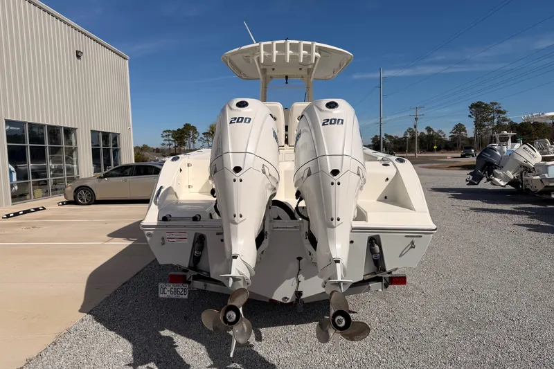 Slide: The Image of 2024 Cobia 262 Center Console boat with dual 200 horsepower engines, parked outdoors. - 3