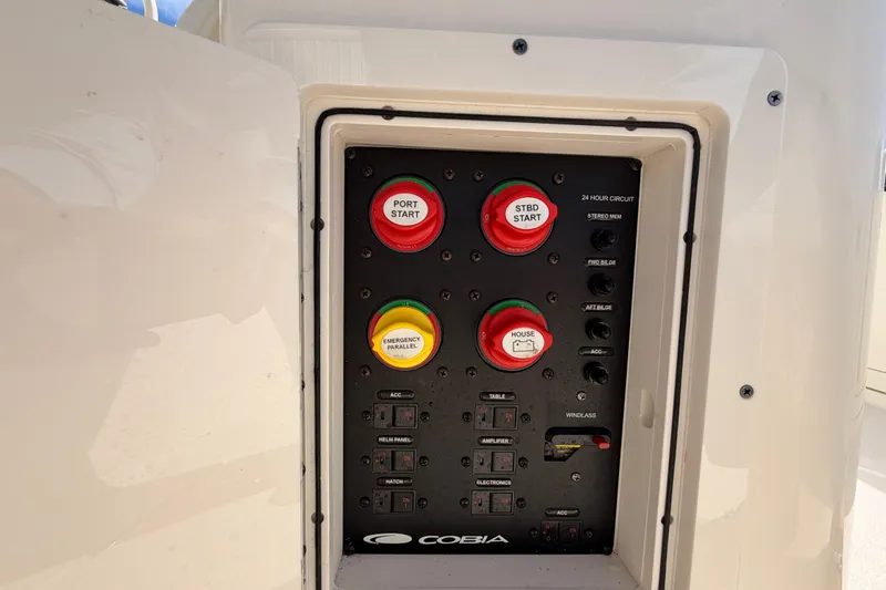 Slide: The Image of Control panel of 2024 Cobia 262 Center Console boat with start buttons and switches. - 31