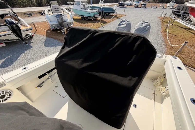 Slide: The Image of 2024 Cobia 262 Center Console boat interior with covered console, docked among other boats. - 33