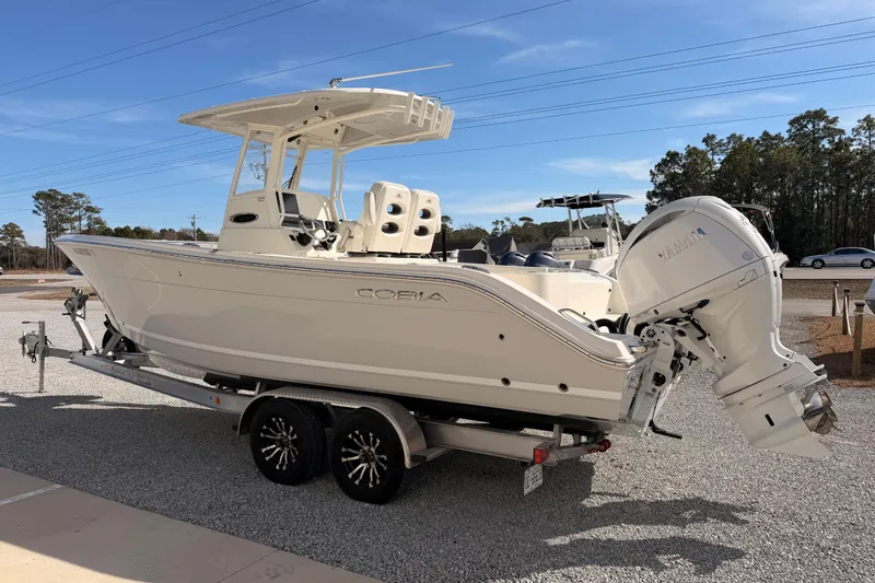 Slide: The Image of 2024 Cobia 262 Center Console boat on trailer, featuring dual outboard engines. - 4