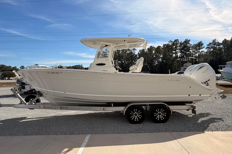 Slide: The Image of 2024 Cobia 262 Center Console boat on trailer, parked outdoors under clear sky. - 5