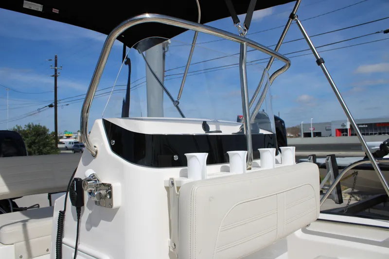 Slide: The Image of 2026 Boston Whaler 150 Montauk boat console with rod holders and steering wheel. - 13