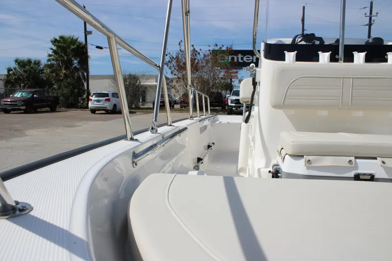Slide: The Image of 2026 Boston Whaler 150 Montauk boat interior with seating and railing, parked outdoors. - 16
