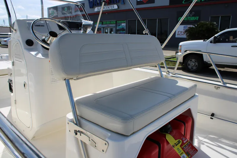 Slide: The Image of 2026 Boston Whaler 150 Montauk boat interior with cushioned seating and steering console. - 19