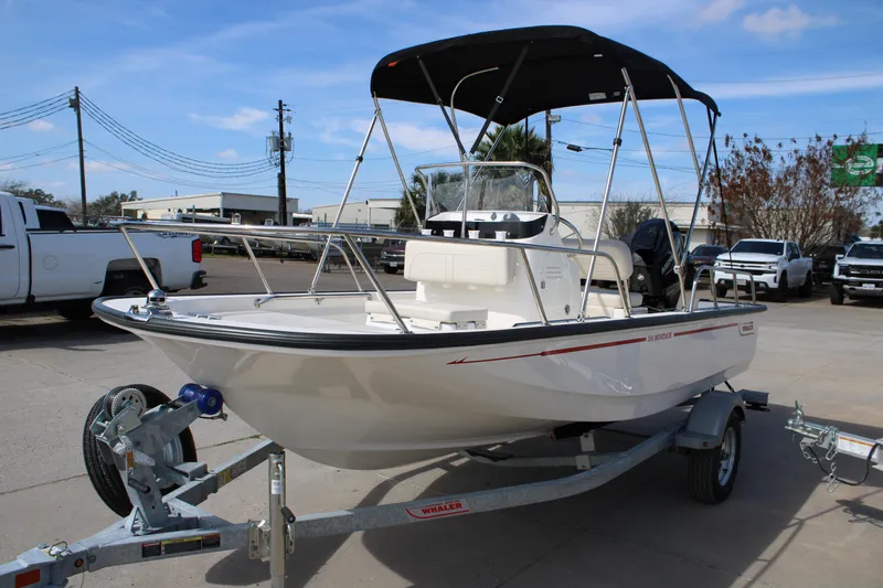 Slide: The Image of 2026 Boston Whaler 150 Montauk boat on trailer, parked outdoors. - 21
