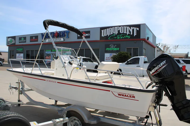 Slide: The Image of 2026 Boston Whaler 150 Montauk boat displayed outside Waypoint Customs shop. - 3
